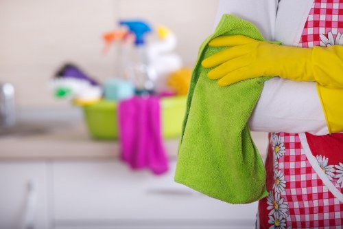 Professional cleaner working in a West Hampstead kitchen and living area